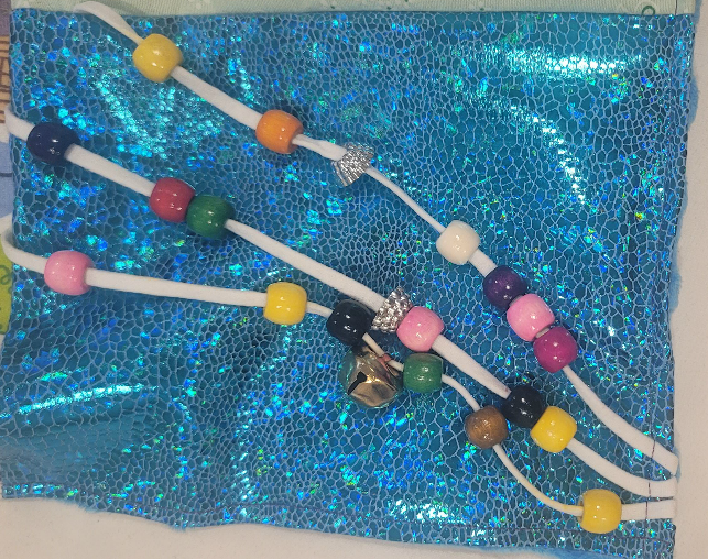 Beads and elastic on shiny backing